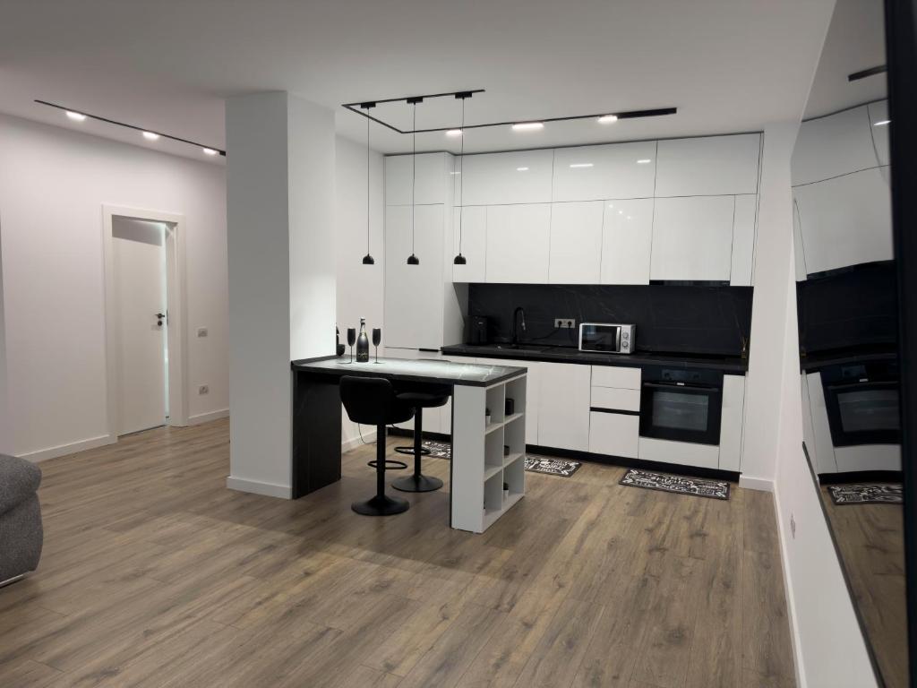 a kitchen with white cabinets and a black counter top at Sterling House in Timişoara