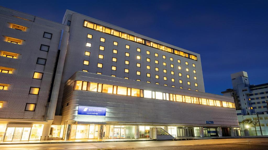 a large building with lights in front of it at Quintessa Hotel Akita in Akita