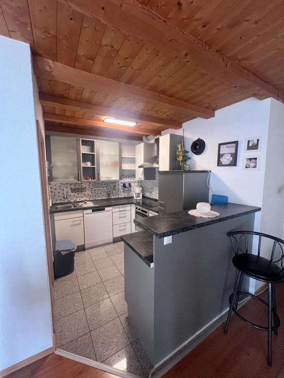 a kitchen with white cabinets and a black counter top at Ferienhof Buschle in Bermatingen