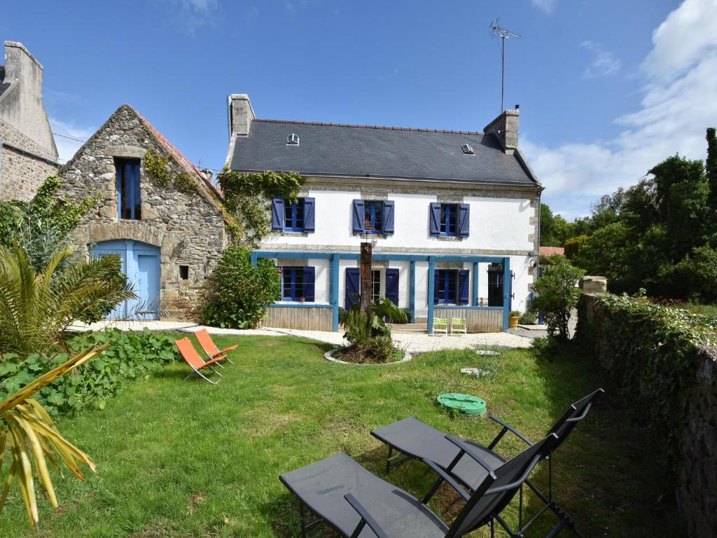a large white house with a yard with chairs at Brittany Escape with Garden in Kersaudy