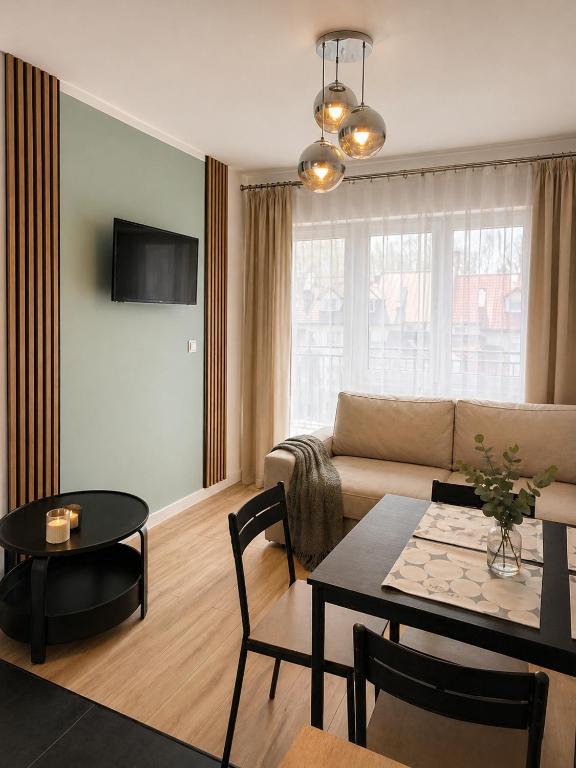 a living room with a couch and a table at Apartamenty Przy Forcie in Kłodzko