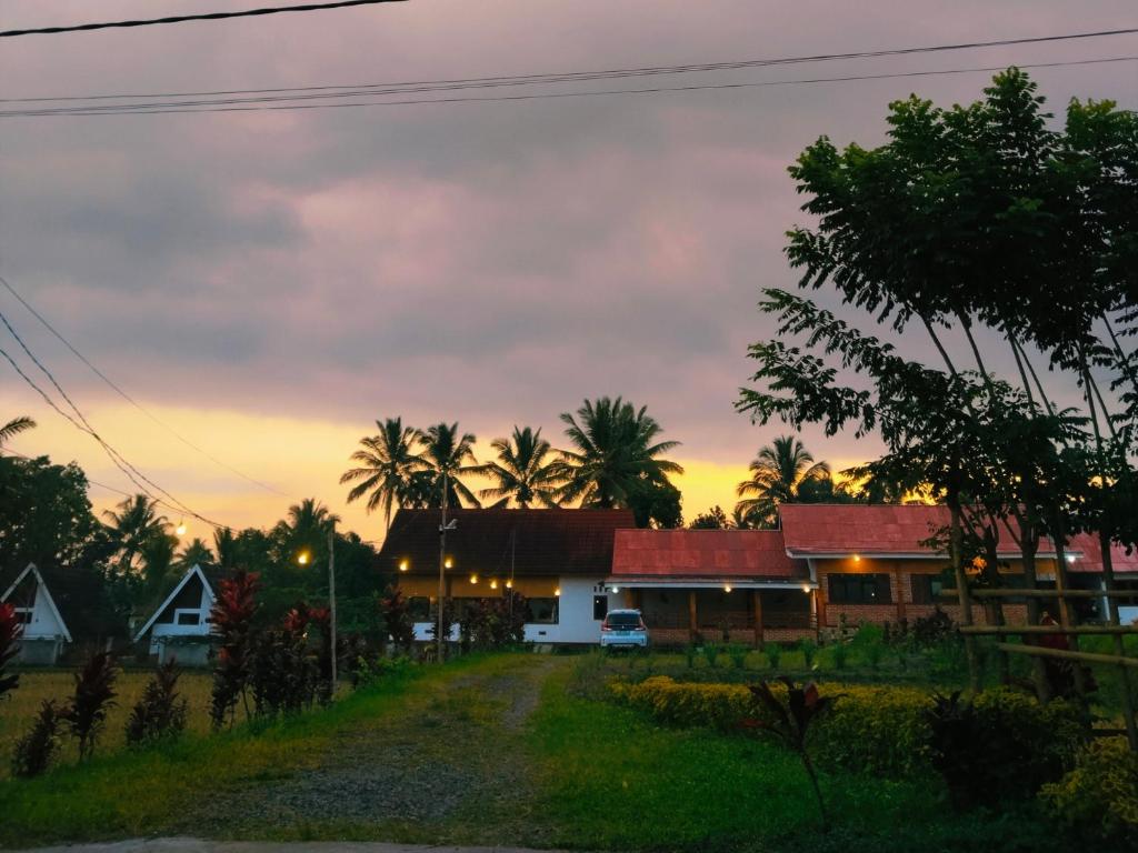 a street in a village at sunset with palm trees at Nan Bungalows Tetebatu in Tetebatu