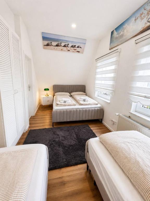 zwei Betten in einem Zimmer mit weißen Wänden und Fenstern in der Unterkunft SmartStay Wuppertal Self Check-in Parking Budget Hotel in Wuppertal