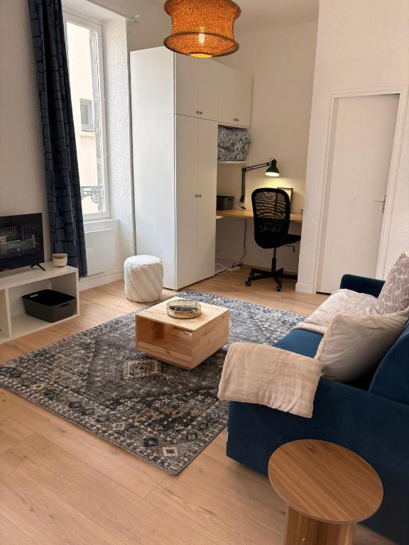 a living room with a blue couch and a table at Studio de Dallet - Coeur de Ville in Clermont-Ferrand