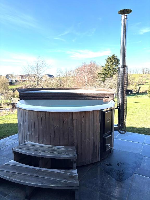 a hot tub sitting on top of a patio at Stone Barn Menil Sauna & Nordic Bath in Ardennes in Hotton