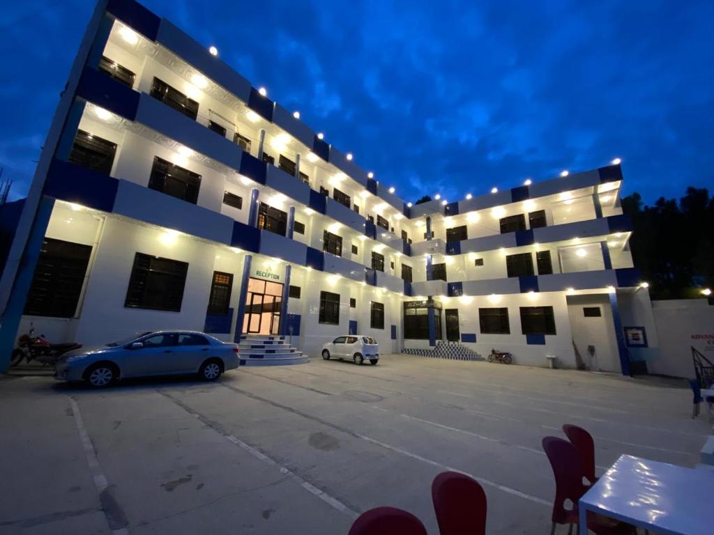 a large building with a car parked in a parking lot at Hotel Hills City, Swat in Mingāora