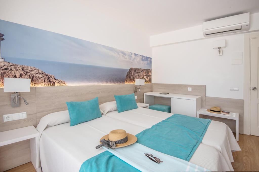 ein Schlafzimmer mit einem Bett, auf dem ein Hut liegt in der Unterkunft Hostal Es Pi - Emar Hotels in Playa Migjorn