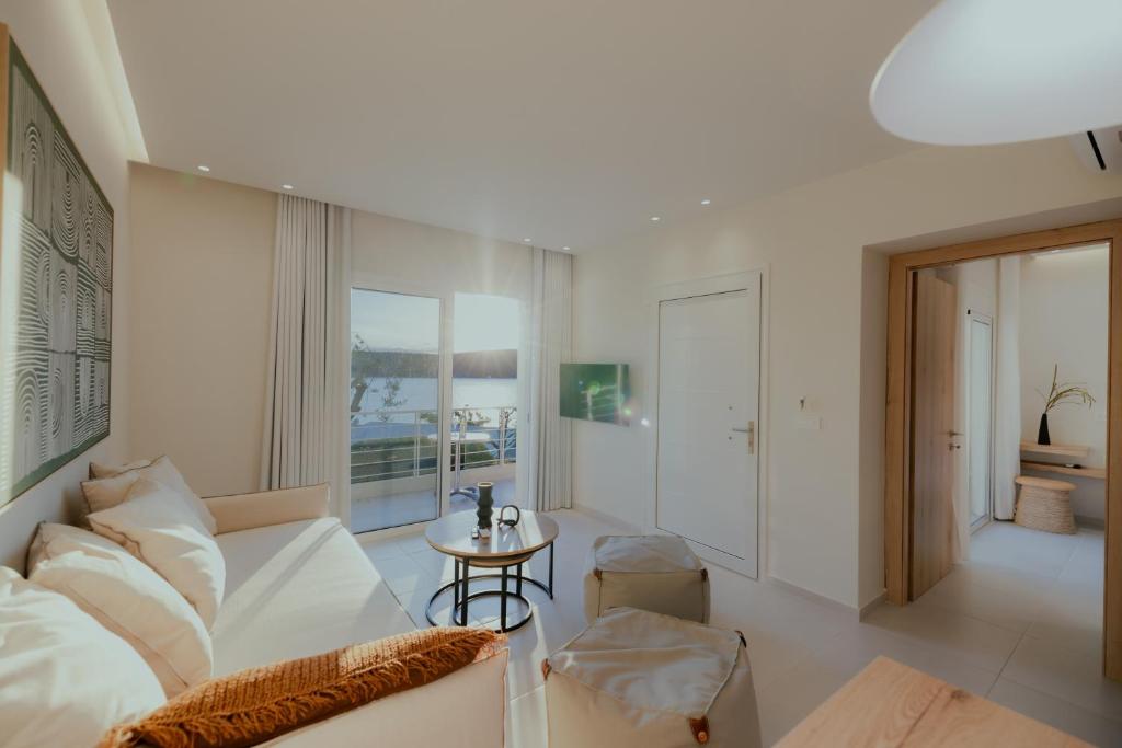 a living room with a white couch and a table at Lefka Apartment in Vivari