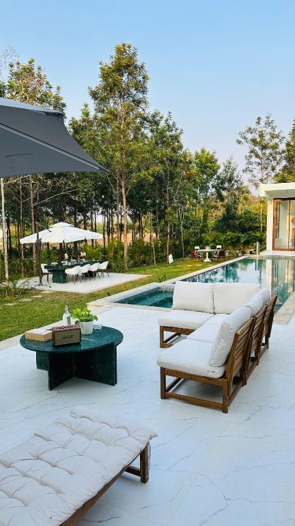 a patio with couches and a table and a pool at Encore by Serenity in Hampāpura