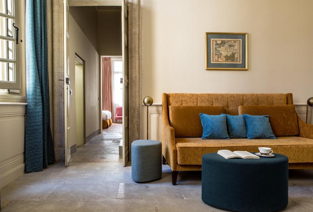 a living room with a couch and blue pillows at La Maison d&#39;Uzès Relais &amp; Châteaux in Uzès