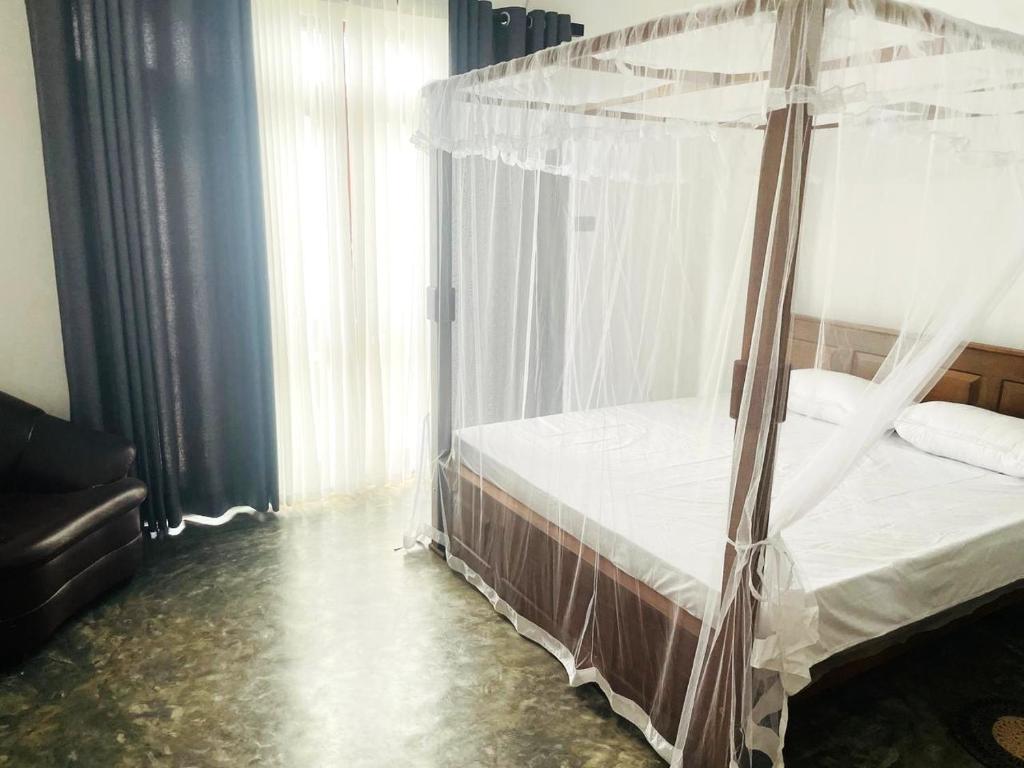 a bedroom with a bed with a canopy at Elysian Riverside in Weligama