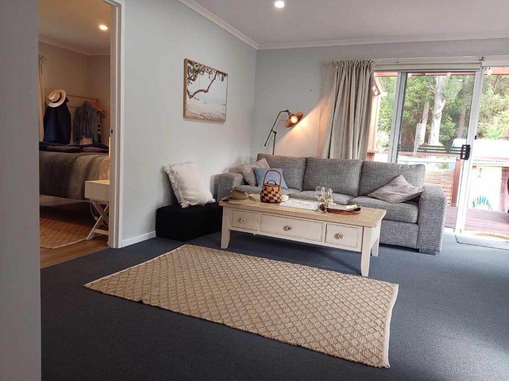a living room with a couch and a coffee table at Beach & Forest Stay in Port Arthur