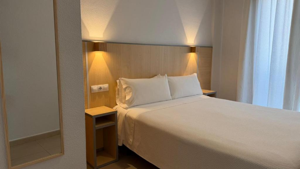 ein Hotelzimmer mit Bett und Spiegel in der Unterkunft Hostal Manuela in Punta Umbría