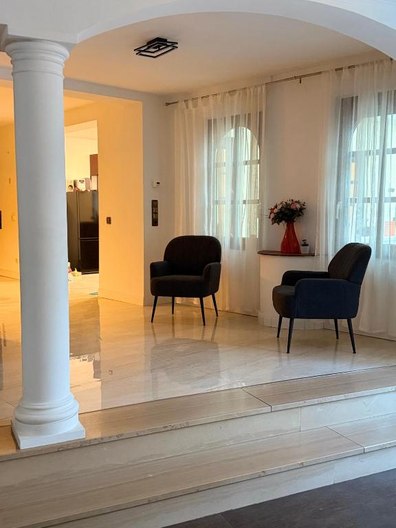 a living room with two chairs and a column at Romantiksuite Euskirchen in Euskirchen