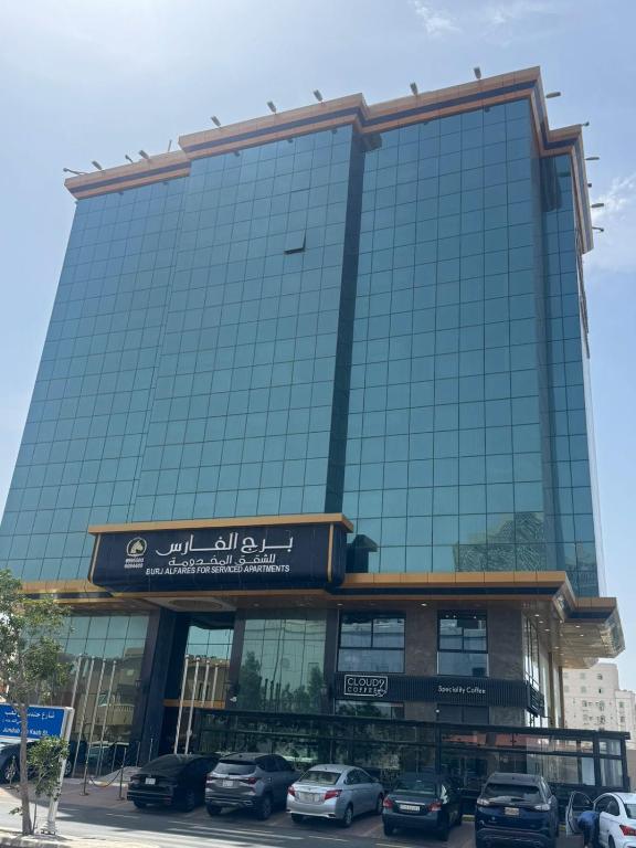 a building with cars parked in front of it at برج الفارس للشقق المخدومة in Jeddah