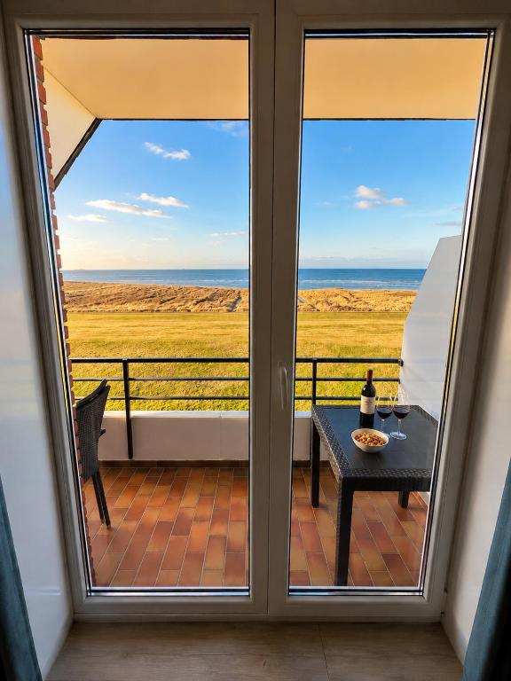 a balcony with a table and a view of the ocean at Haus Nige Wark - Ferienwohnungen in Cuxhaven