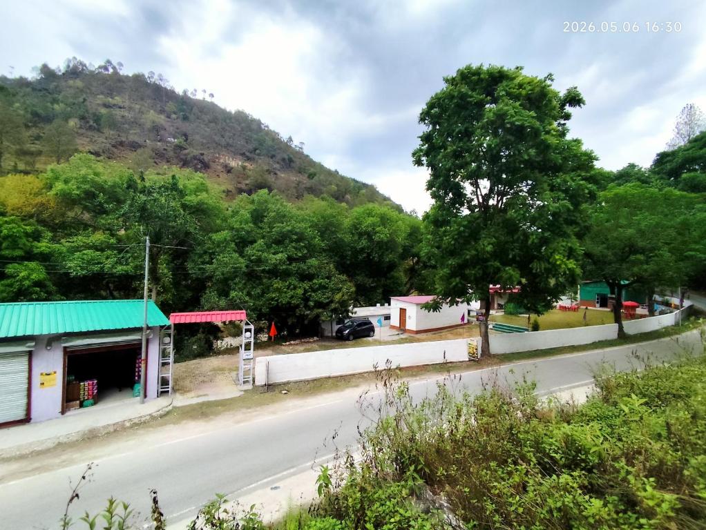 a street in a small town with a mountain at The Ghunadi Greens in Bāgeshwar