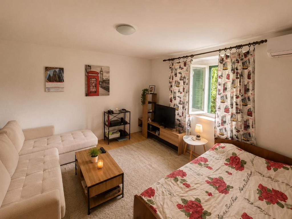 a living room with a couch and a tv at Apartman Mediteran in Herceg-Novi