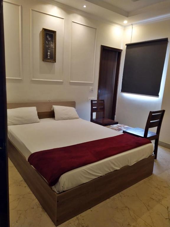 a bedroom with a large bed and two chairs at Hotel Sahajtam Inn in Sonīpat