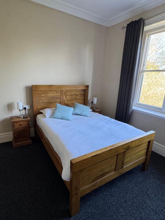 a bedroom with a large wooden bed with blue pillows at The Briary in Sheffield