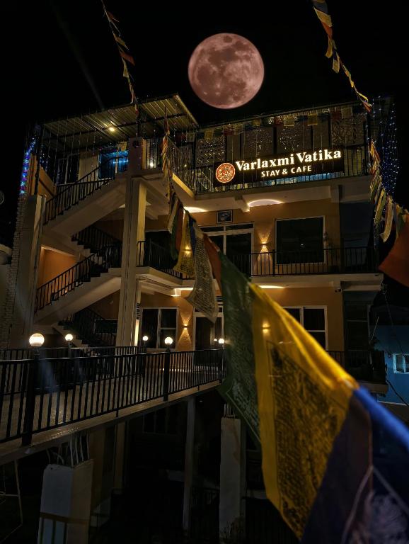 a full moon rises over a building at night at Varlaxmi Vatika in Rānīkhet