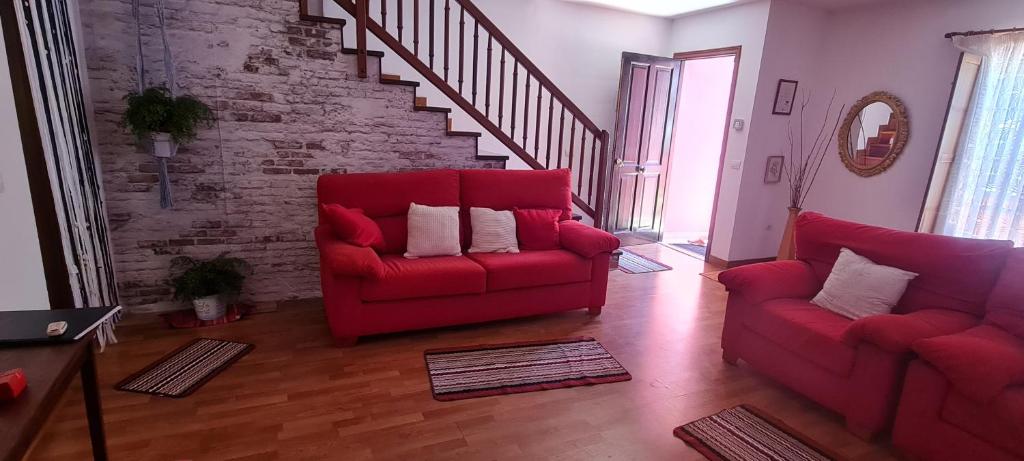 a living room with a red couch and a staircase at Mgrahamhouse in Tacoronte