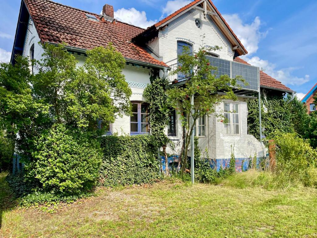 a white house with a red roof at Deichliebe 290 Ökologisches Ferienhaus Stöckte in Winsen