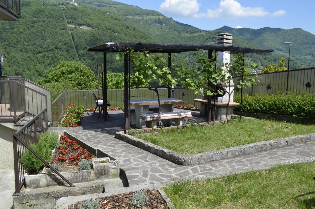 ein Garten mit Picknicktisch und Pergola in der Unterkunft Al Canto in Rota d'Imagna