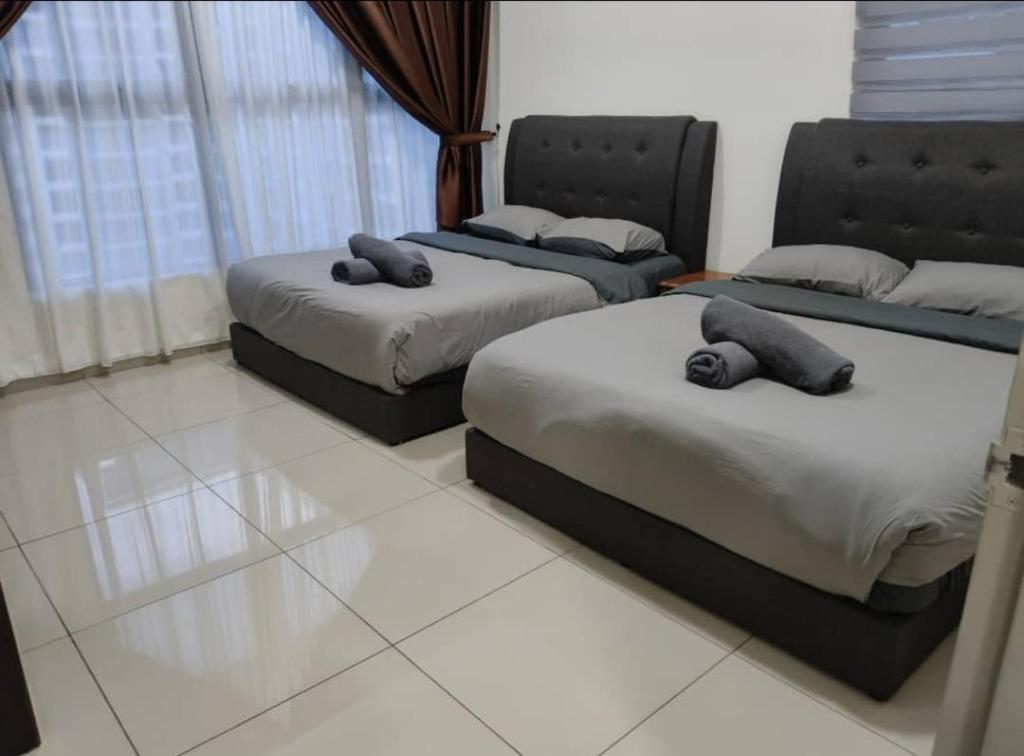 a bedroom with two twin beds and a window at Atlantis Residence BA in Malacca