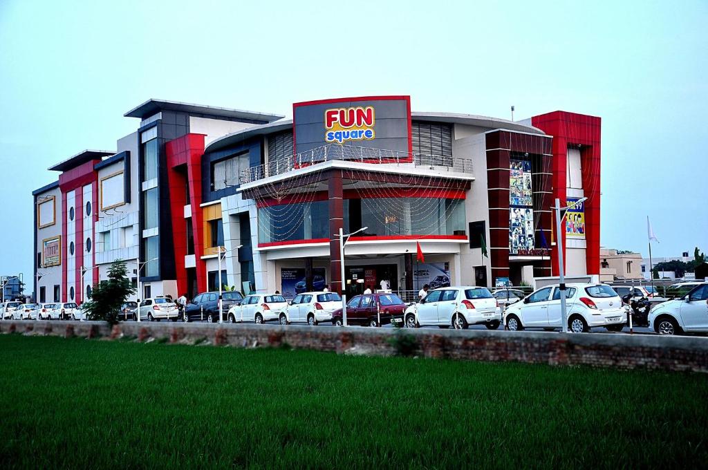 a fun store with cars parked in a parking lot at Fun Square Hotel in Sangrūr