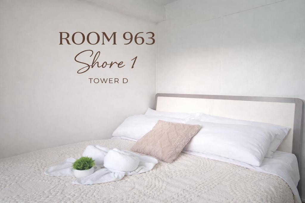 a bedroom with a bed with white sheets and pillows at 963 D shore 1 in Manila