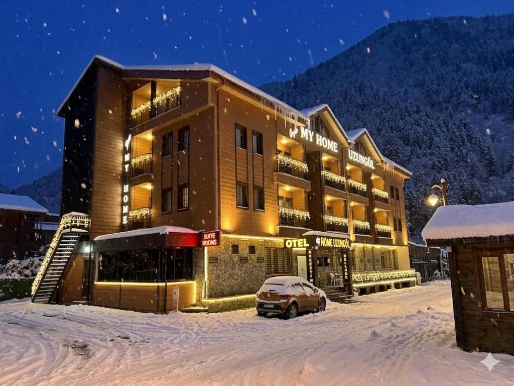 a building with a car parked in the snow at My Home Uzungöl in Uzungöl