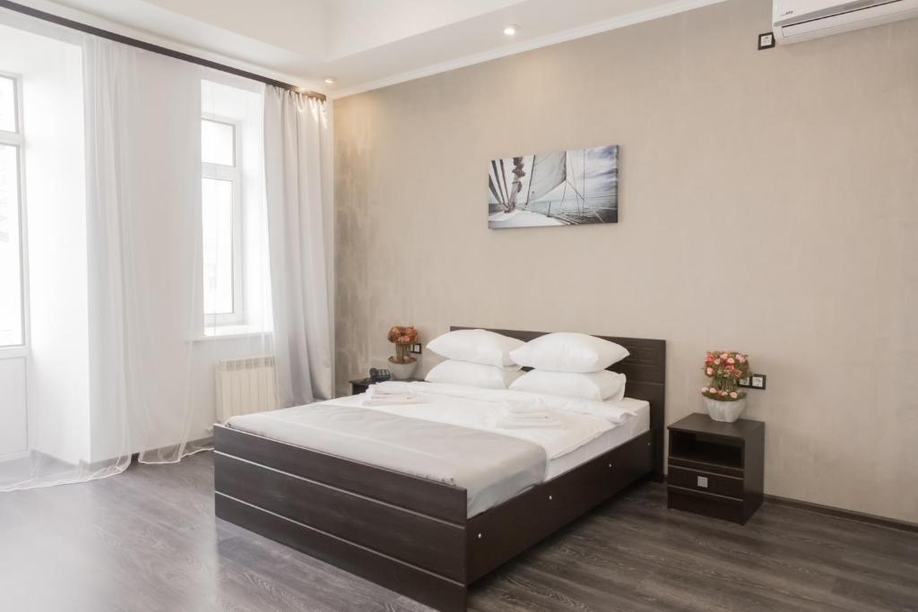 una camera da letto con un grande letto con lenzuola e cuscini bianchi di Hotel Loft a Samara