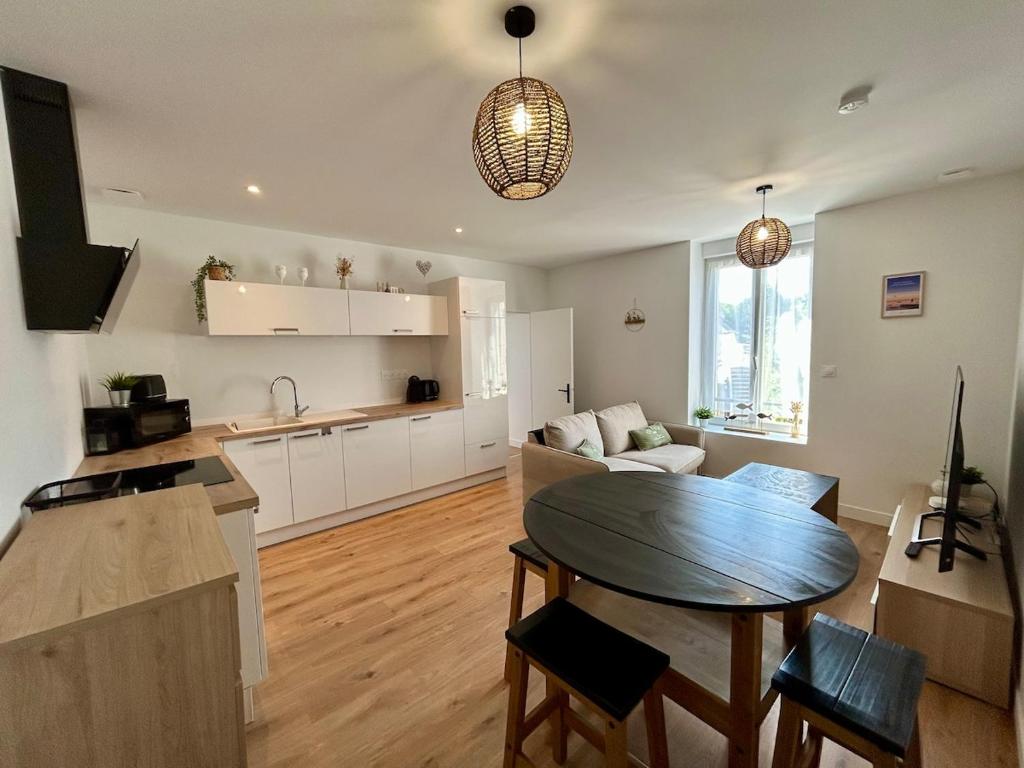 a kitchen and a living room with a table in a room at Le 200 de la cale in Fouesnant