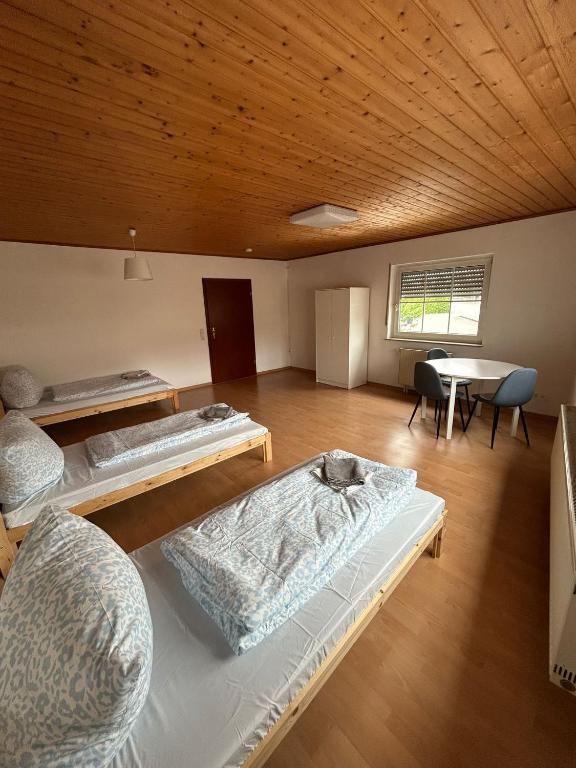 a room with three beds and a table in it at ME Apartments - Big Space in Bad Camberg