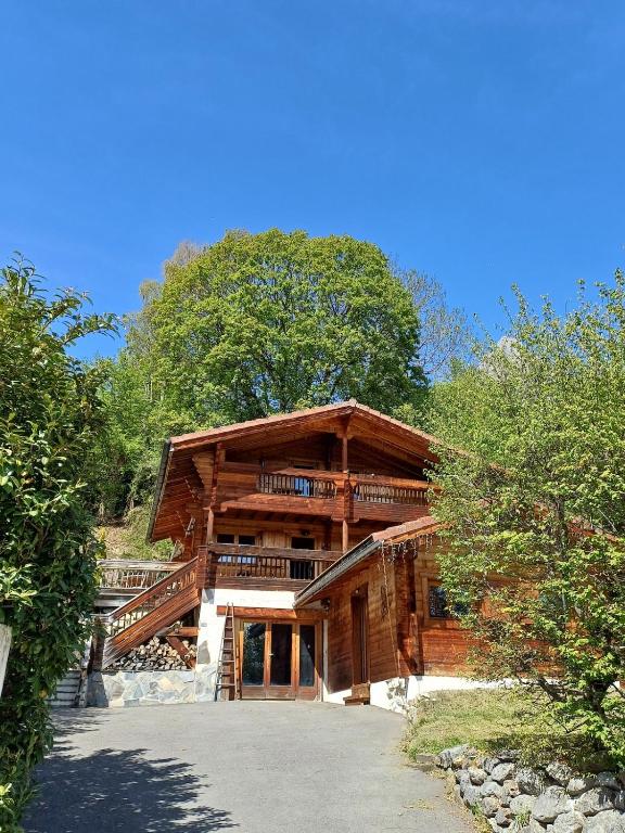 a large wooden house with stairs on it at Magnifique chalet , 10 personnes, vue panoramique, bain nordique in Passy