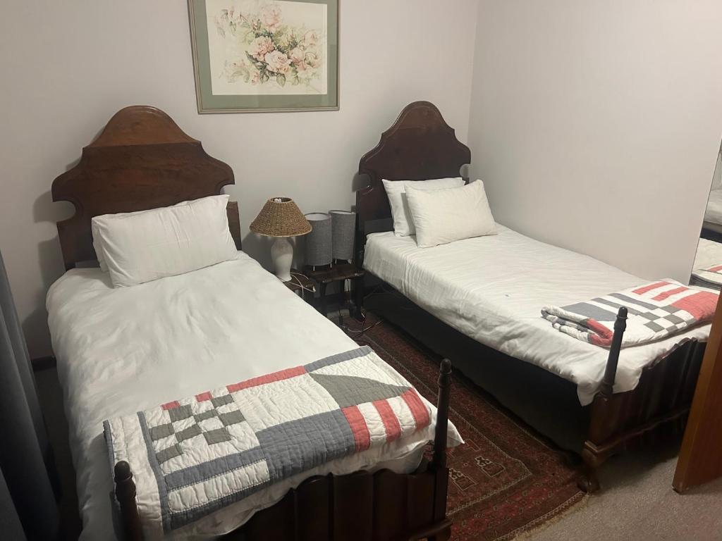 a bedroom with two beds and a quilt on the bed at 13 bedford street in Grahamstown