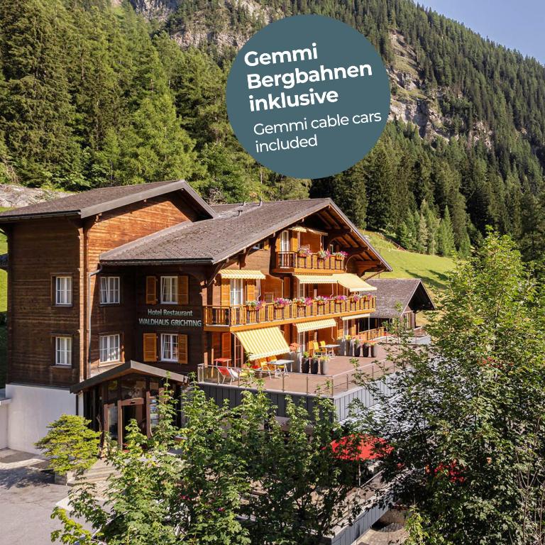 a large wooden house in the middle of a mountain at Hotel Restaurant Waldhaus in Leukerbad