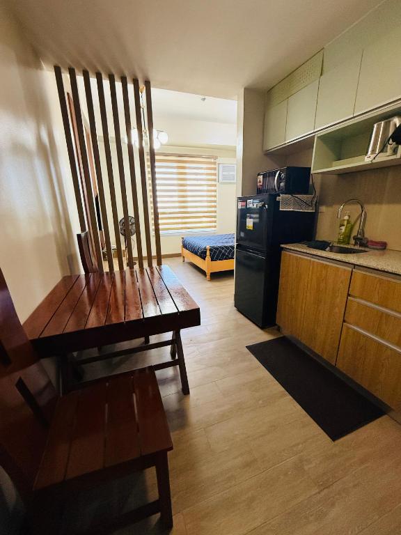 a kitchen with a wooden table and a kitchen with a refrigerator at Refreshing Condo hotel in General Trias