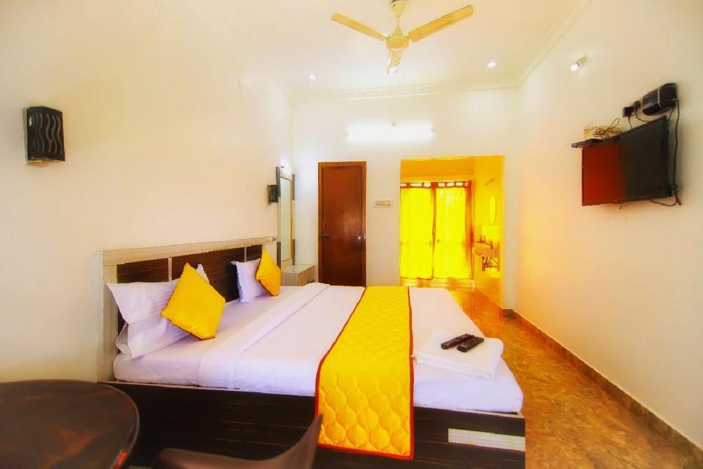 a bedroom with a large bed and a television at Bluebell Holiday Inn in Yercaud