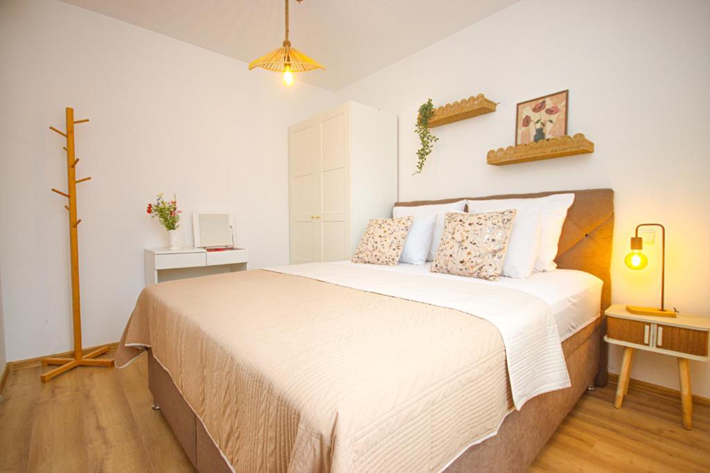 a bedroom with a large bed with white sheets at Apartments Katušić in Cavtat
