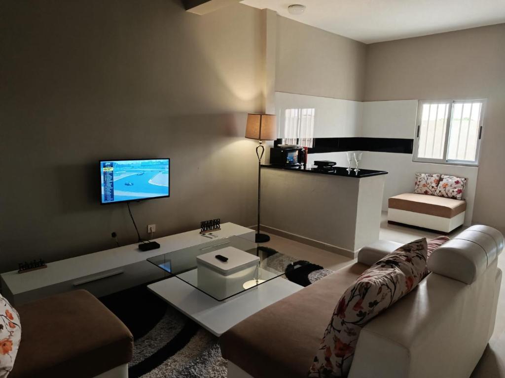 a living room with a couch and a tv at Residencial Biva in Namibe