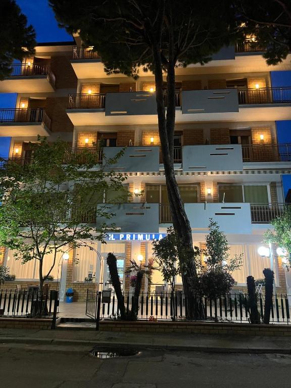 a large white building with lights in front of it at Hotel Primula in Lido di Savio