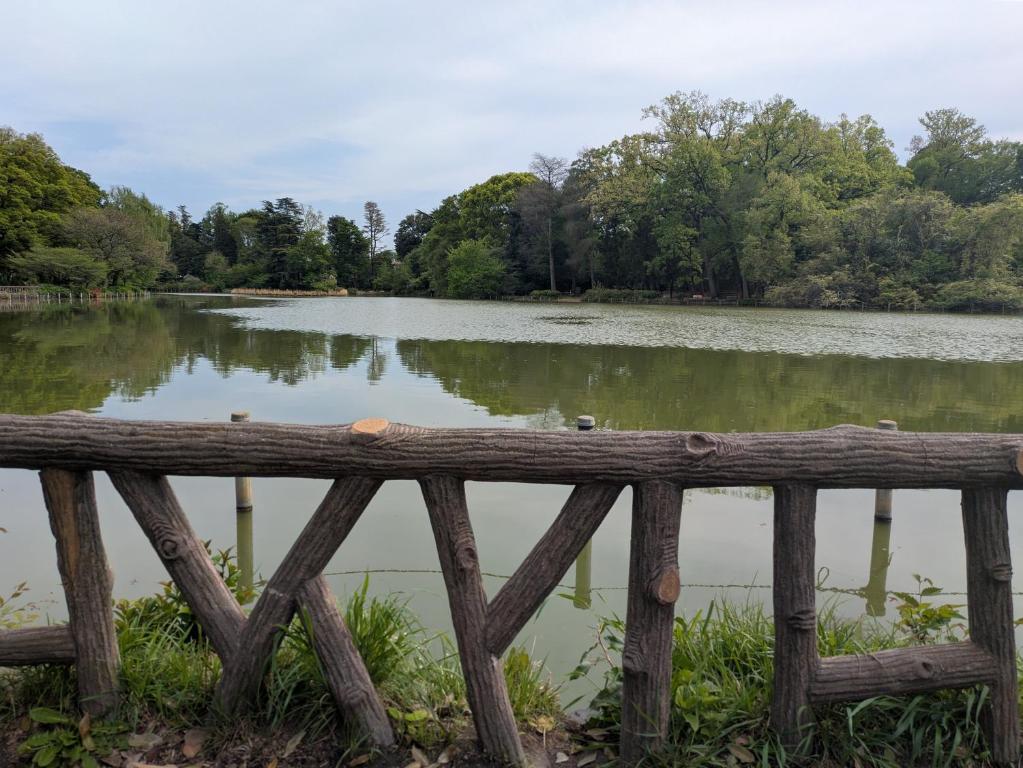 a wooden fence in front of a lake at KazenoKi in Kichijōji