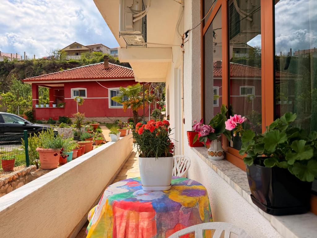 a table on a balcony with flowers on it at Mert Jacellari Guesthouse in Pogradec