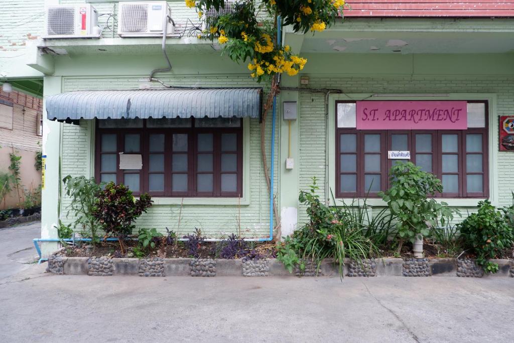 ein grünes Haus mit einem Schild an der Vorderseite in der Unterkunft ST Apartment in Dusit
