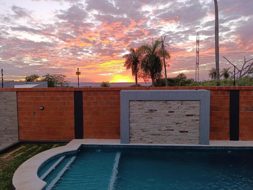 a swimming pool with a sunset in the background at Tajesdelsol in Luque