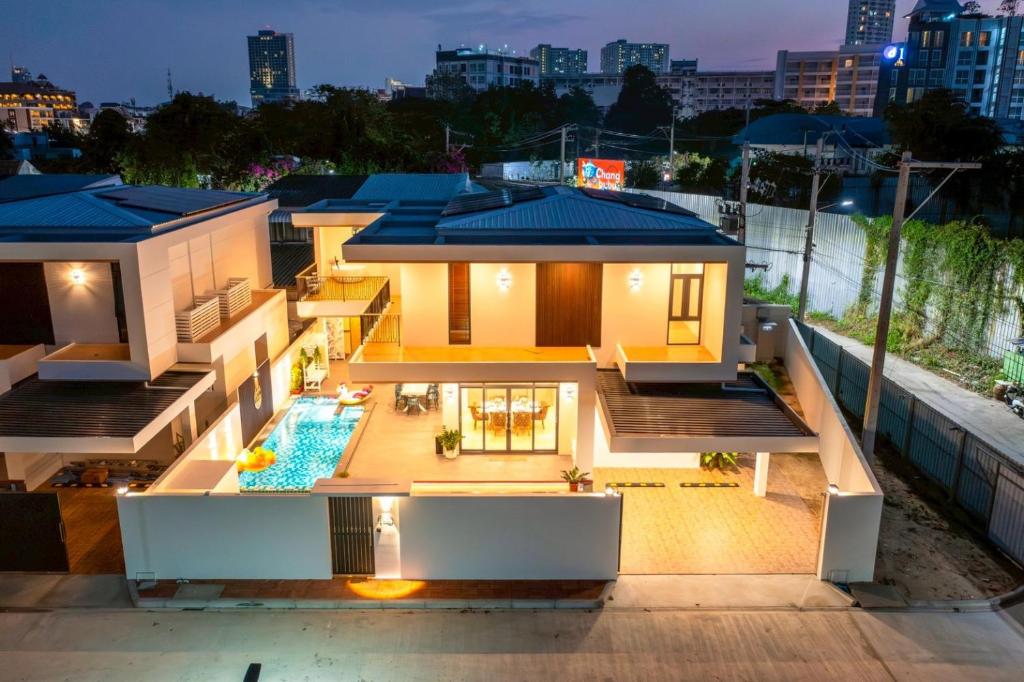 a house with a swimming pool at night at Morning Sea 1 เปิดใหม่!! พัทยาเหนือใกล้ทะเล ใกล้ Terminal21 in North Pattaya
