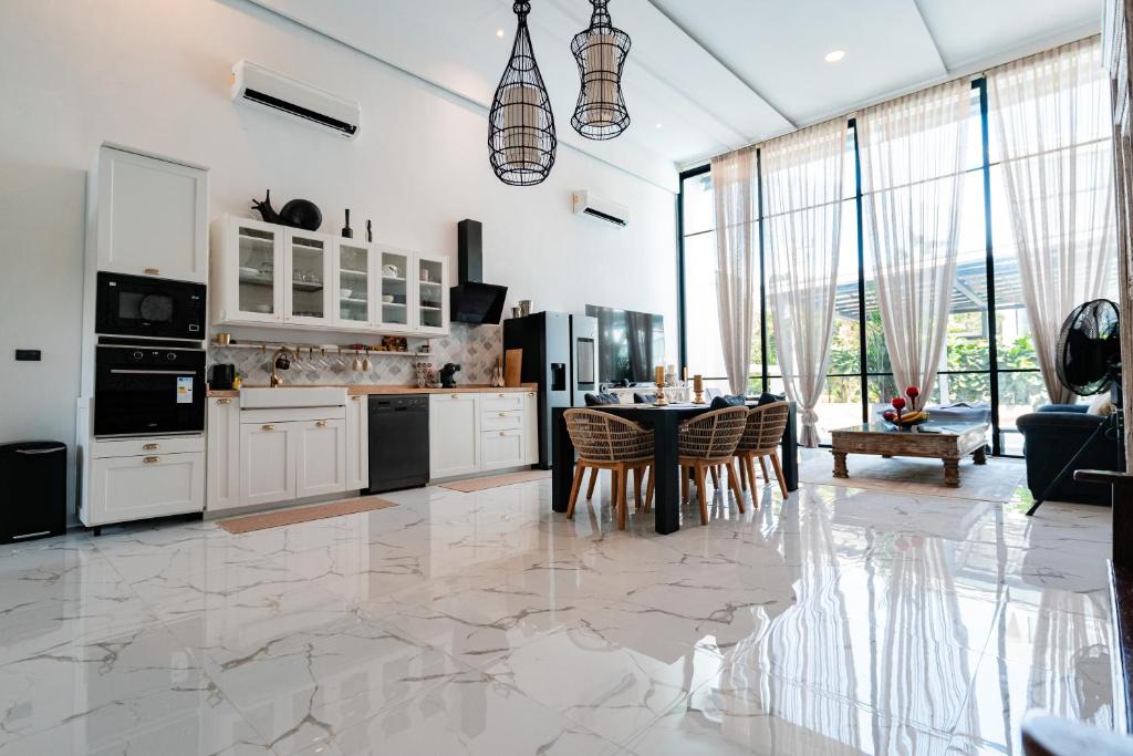 a kitchen with a table and a dining room at Replay R6 Pool Villa in Bophut
