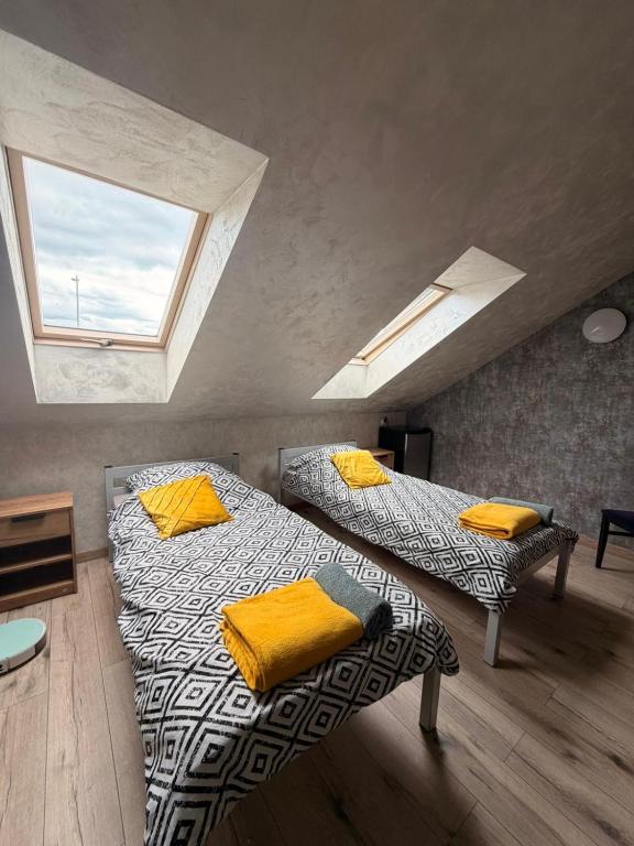 a attic bedroom with two beds and a window at Apartament 4 Słoneczna in Ełk